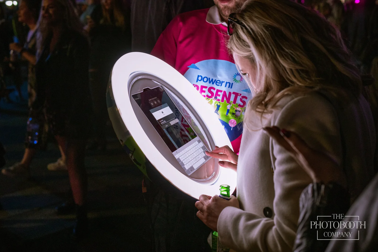 Guest using an interactive roamer booth with a ring-light tablet and instant sharing at a branded corporate event